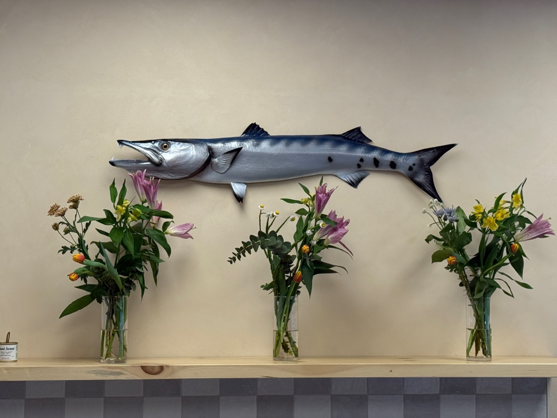 Barracuda décoratif au-dessus de bouquets de fleurs fraîches dans la salle de Maui Poke+Café