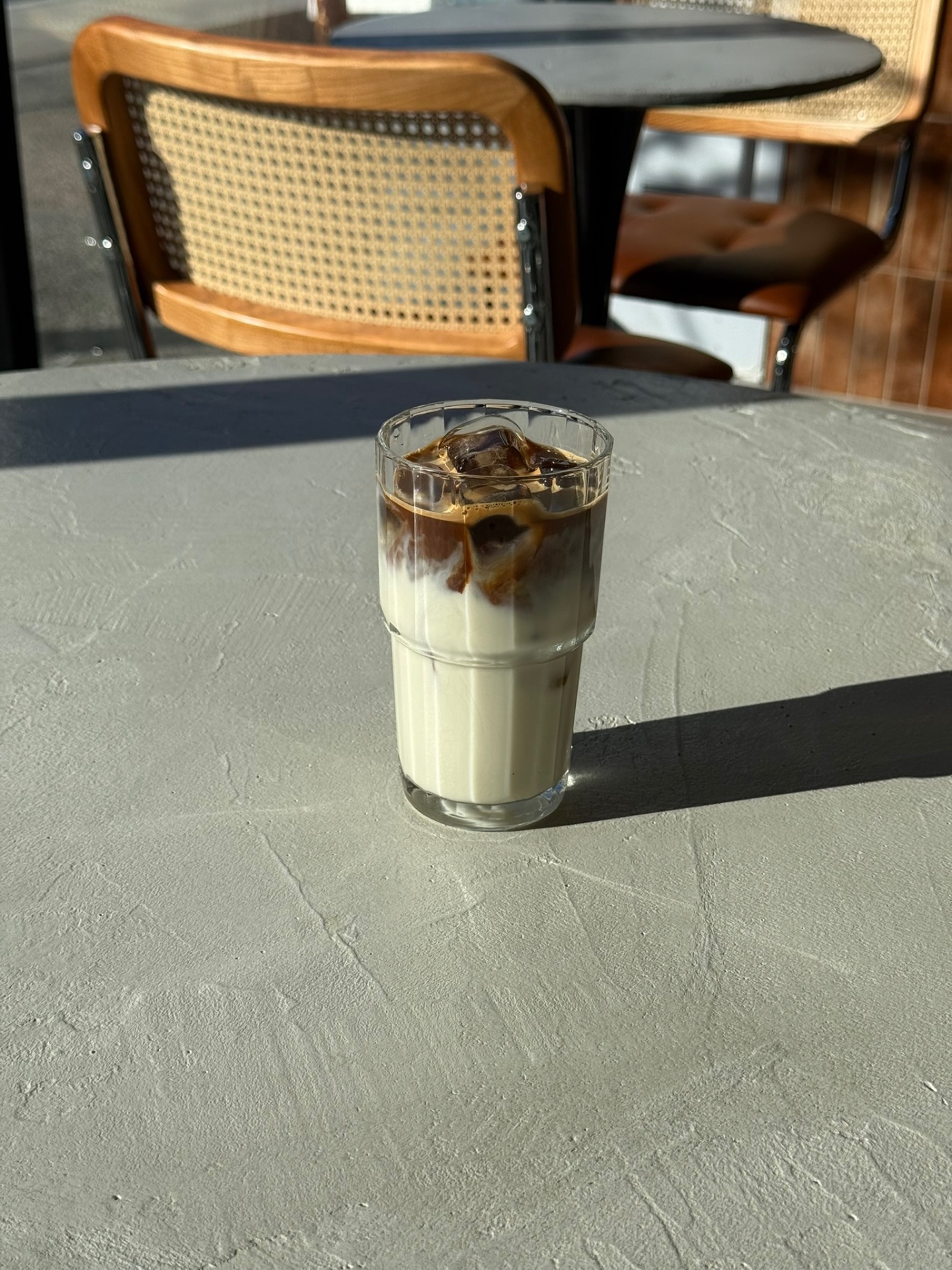 Latte glacé caramel dans un verre cannelé au soleil