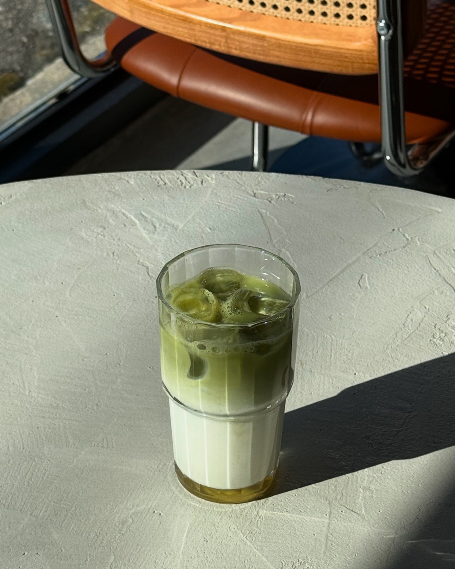 Matcha latté glacé en dégradé vert sur table claire